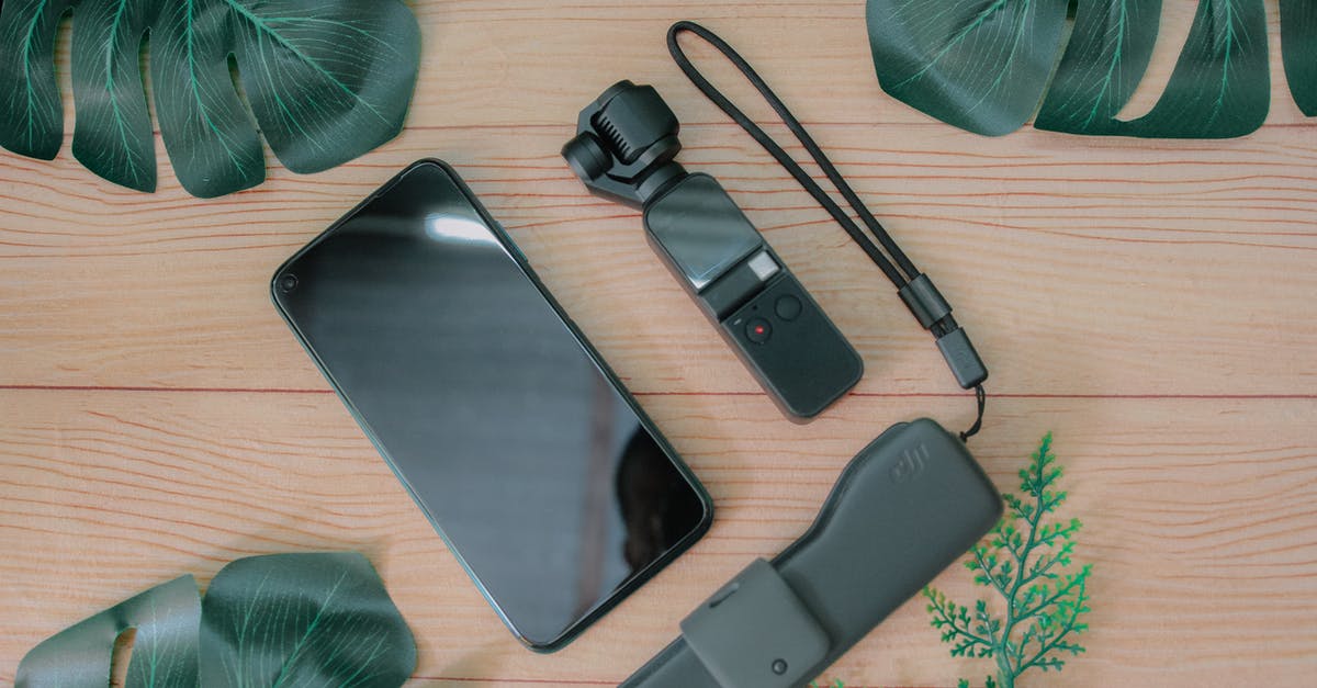 What is hardware video decoding, and should I enable it? - Top view composition of mobile phone placed near USB flash drive and mini gimbal camera on wooden table with green foliage