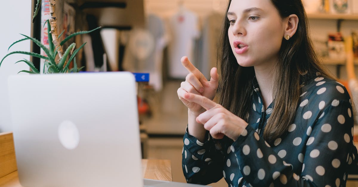 What is that distance on the chat? - Focused young woman having video call on netbook in modern workspace