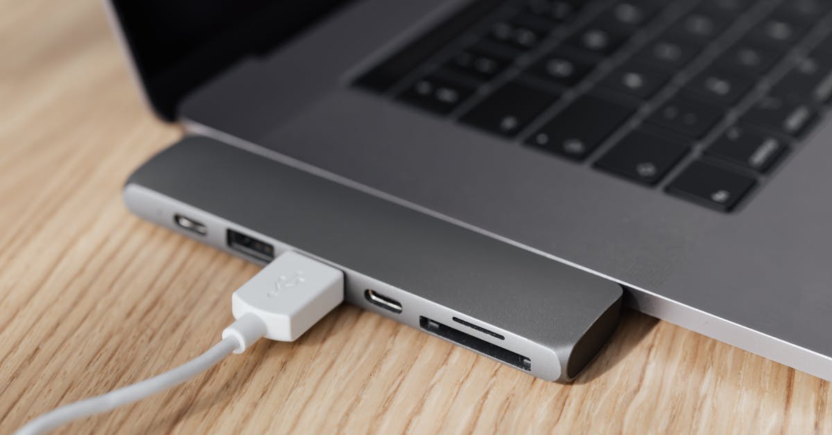 What is the actual purpose of the USB port in the PSTV? - High angle of modern space silver laptop with USB type c multiport hub with plugged white cable placed on wooden table