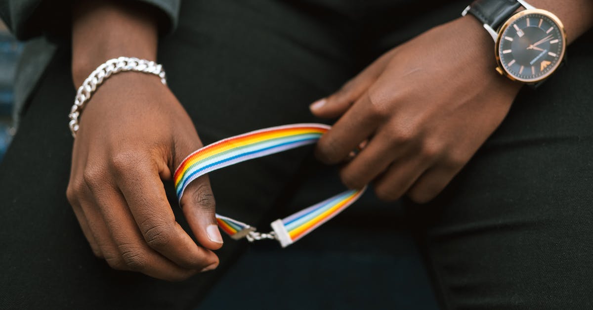 What is the benefit of Accept Culture change? - Crop anonymous African American homosexual male in casual clothes holding bright gay bracelet What is the benefit of Accept Culture change? - Crop anonymous African American homosexual male in casual clothes holding bright gay bracelet