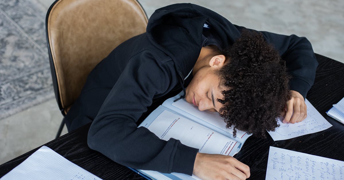 What is the benefit of the Overload mechanic? - High angle of exhausted African American student resting on opened textbook and papers while preparing for exam