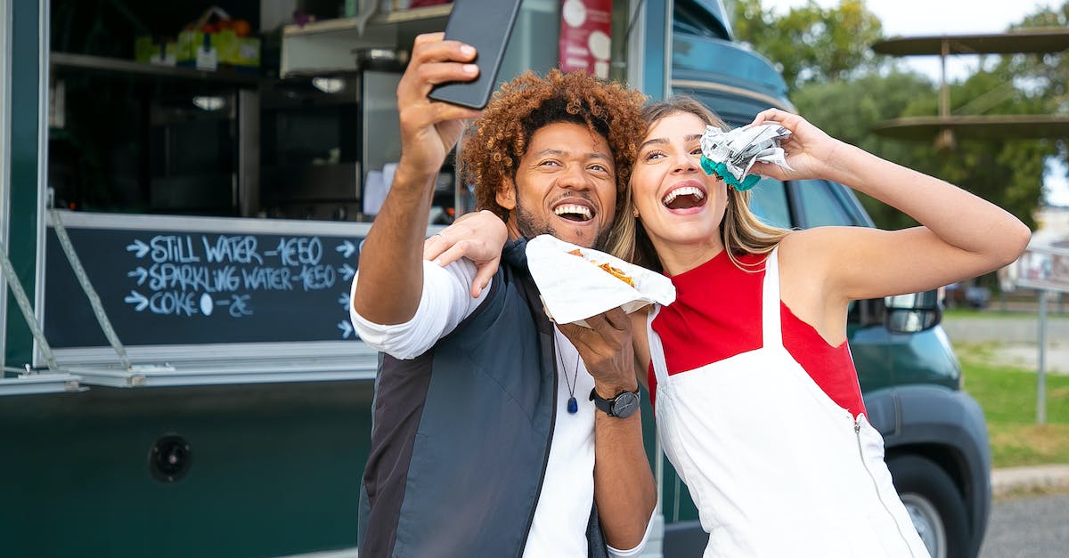 What is the best way to eat automatically in direwolf20 1.7 pack? [duplicate] - Joyful multiracial friends embracing and taking selfie on cellphone while eating tasty burgers near food truck in lush park