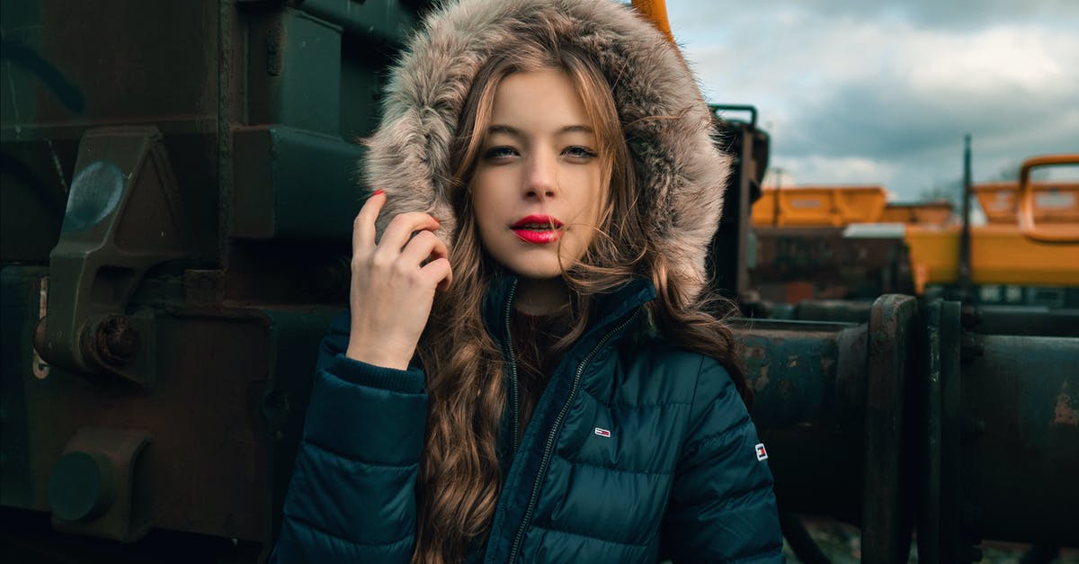 What is the best way to look under Juliet's skirt? - Serious young woman in warm clothes standing on railway near train and looking at camera What is the best way to look under Juliet's skirt? - Serious young woman in warm clothes standing on railway near train and looking at camera
