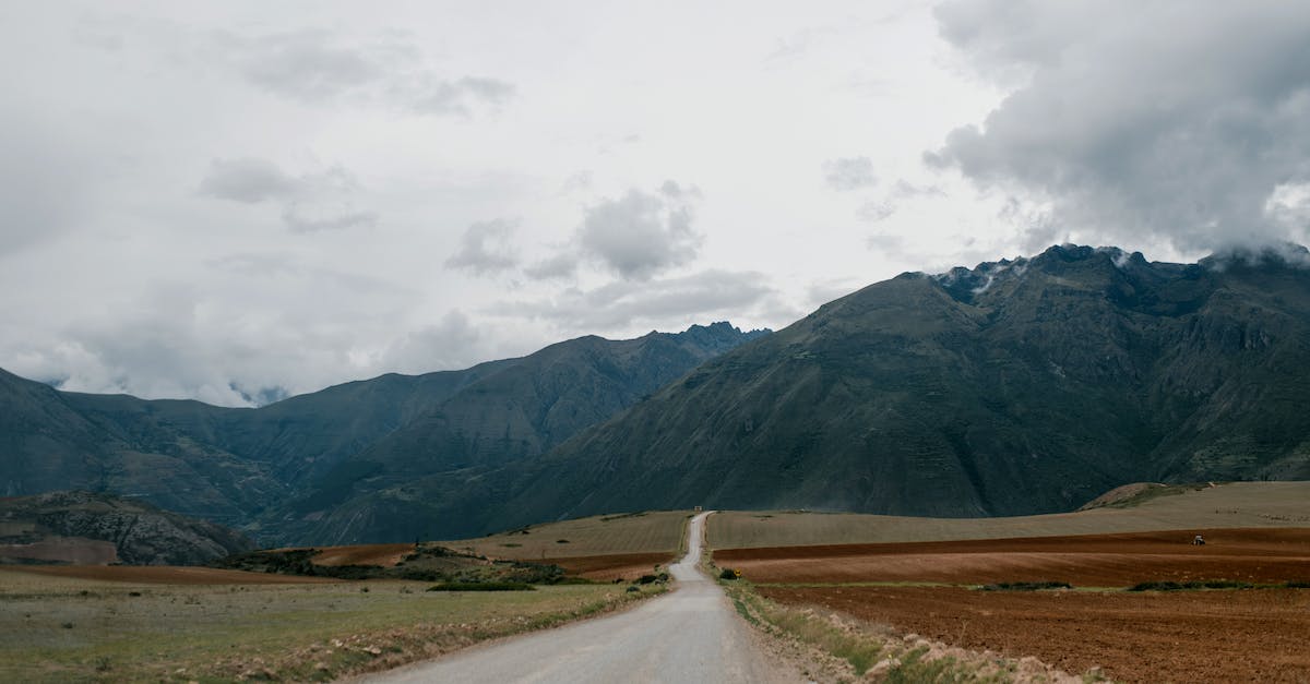 What is the best way to obtain a ridiculously high score in Goat Ville? - Empty road leading towards high mountains with clouds above What is the best way to obtain a ridiculously high score in Goat Ville? - Empty road leading towards high mountains with clouds above