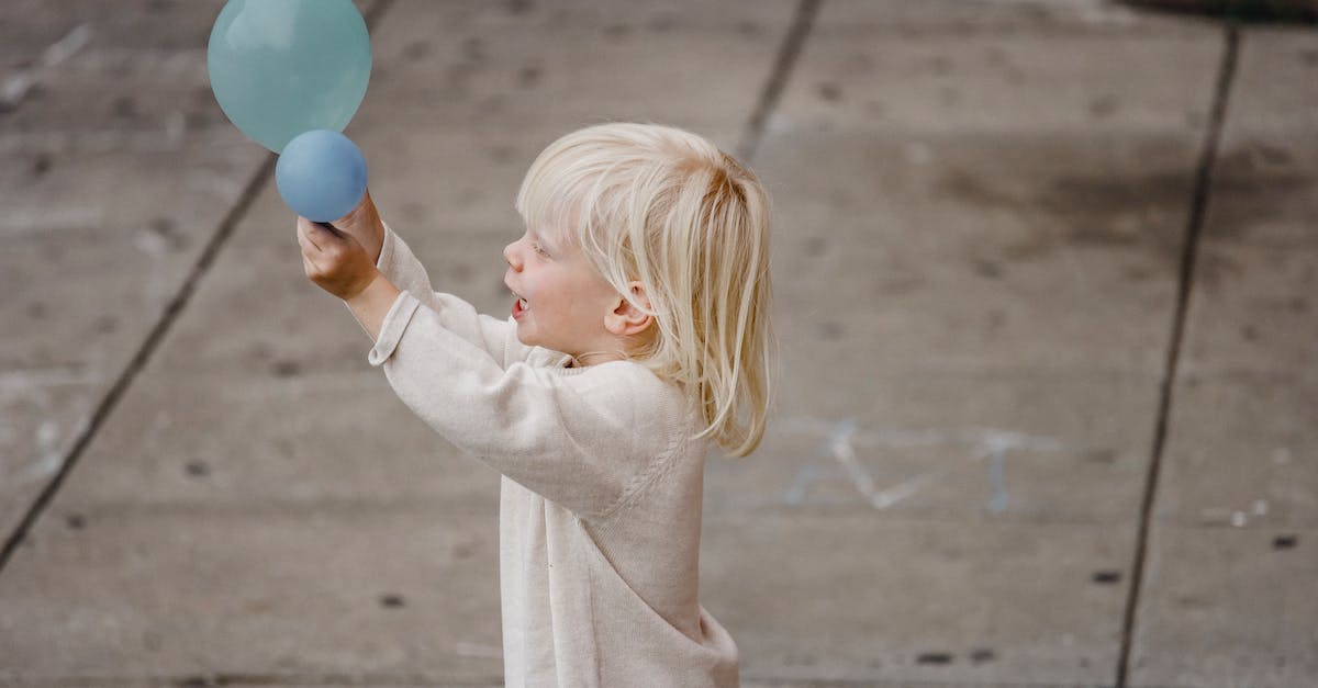 What is the blue/grey balloon on Happy Street? - Happy boy playing with balloon on street What is the blue/grey balloon on Happy Street? - Happy boy playing with balloon on street