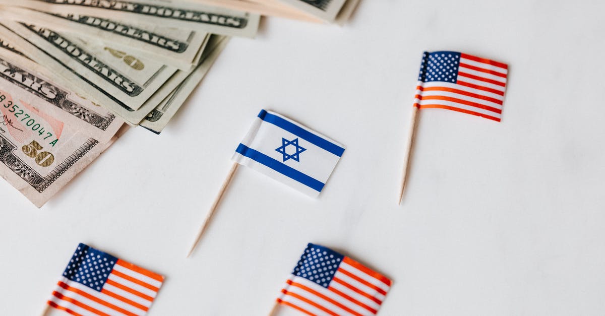 what is the difference between a flag and a teleporter? - From above closeup of Israeli and American flags on toothpicks and different nominal pars of dollar banknotes on white background what is the difference between a flag and a teleporter? - From above closeup of Israeli and American flags on toothpicks and different nominal pars of dollar banknotes on white background
