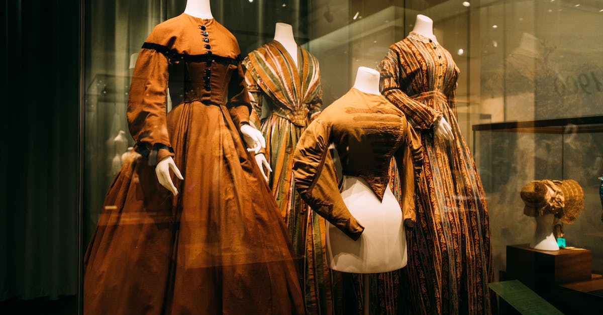 What is the difference between a Mannequin and a Womennequin? - Through glass view of bright ornamental aged female dresses on mannequins on exhibition What is the difference between a Mannequin and a Womennequin? - Through glass view of bright ornamental aged female dresses on mannequins on exhibition