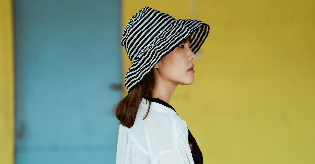 What is the difference between blue and striped blue-and-white defeated levels? - Pensive woman in striped hat standing near yellow wall What is the difference between blue and striped blue-and-white defeated levels? - Pensive woman in striped hat standing near yellow wall