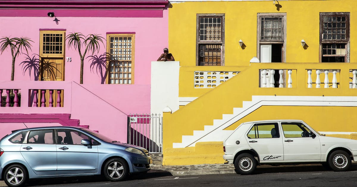 What is the difference between Fulgore and Spinal auto triples? - Distant African American man standing between pink and yellow residential buildings located near road with parked cars on street in town What is the difference between Fulgore and Spinal auto triples? - Distant African American man standing between pink and yellow residential buildings located near road with parked cars on street in town