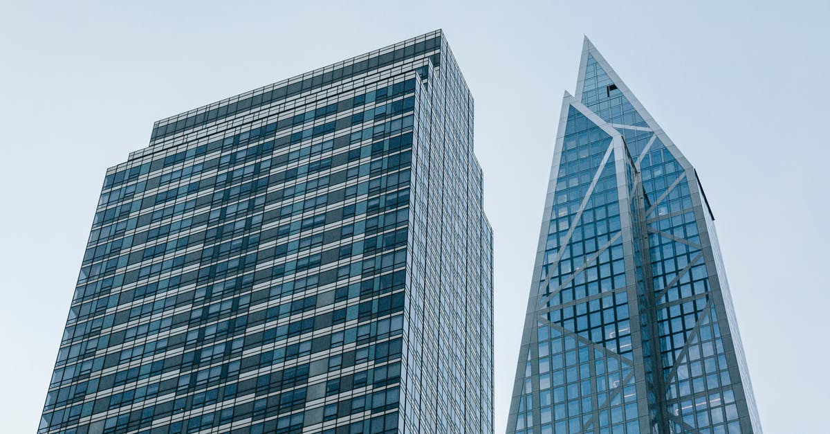 What is the difference between Low and High Advice? - Low angle of contemporary multistory house facades with geometric walls under light blue sky in town