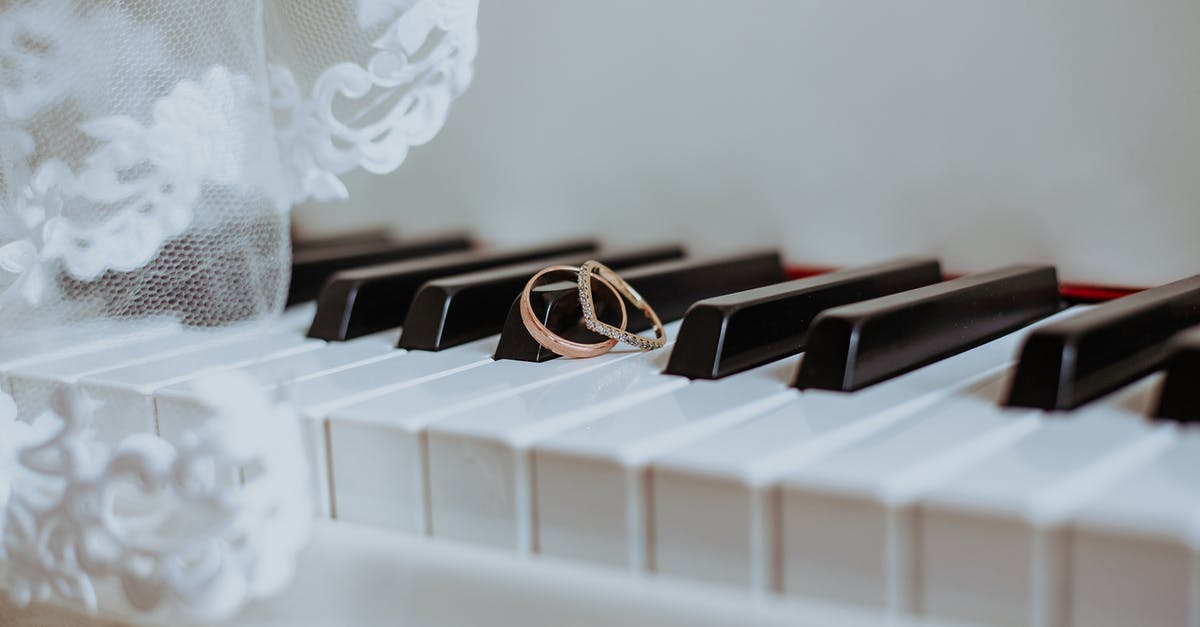 What is the difference/benifit of golden cards? [duplicate] - Golden rings on piano keyboard under veil with ornament during festive event in daytime
