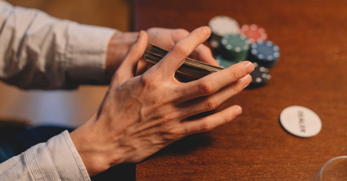 What is the drug dealer playing in the film Kick-Ass? - A Person Holding a Playing Cards Near the Wooden Table What is the drug dealer playing in the film Kick-Ass? - A Person Holding a Playing Cards Near the Wooden Table