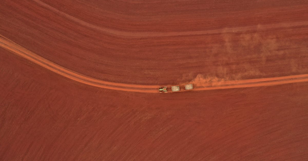 What is the fastest way to get the Accelerated Production achievement? - Drone view of tractor driving on dusty rural road between plowed fields in agricultural village What is the fastest way to get the Accelerated Production achievement? - Drone view of tractor driving on dusty rural road between plowed fields in agricultural village