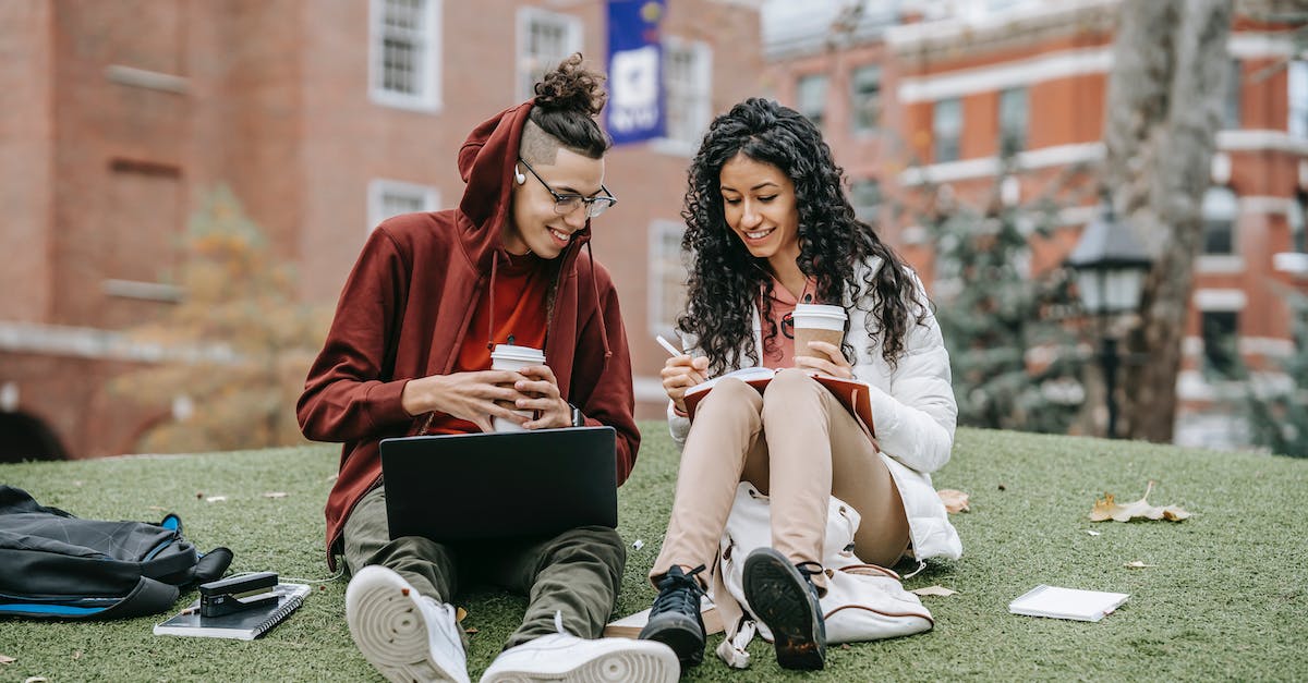 What is the full research tree? - Cheerful multiethnic students with laptop and copybook studying on grassy lawn