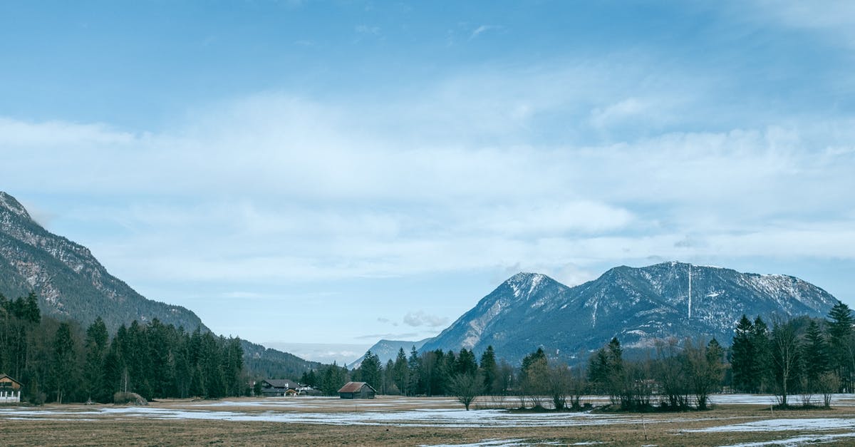 What is the impact on Mob spawning if rendering range is small? - Small village on land with evergreen trees and snowy mountains
