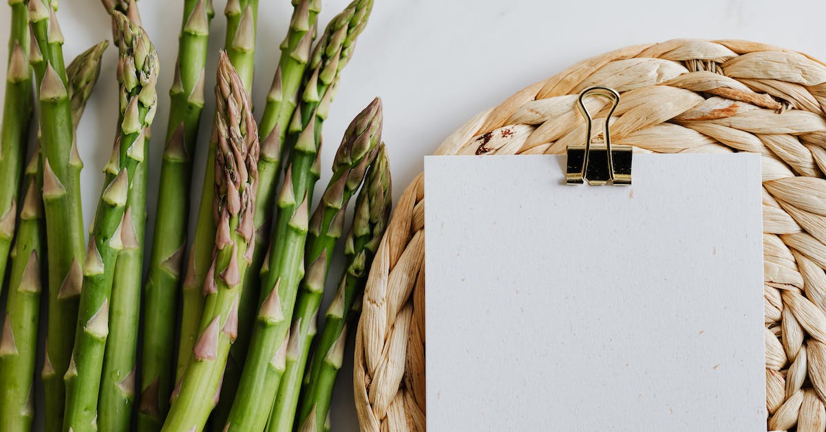 What is the list of ingredients for recipe #99? - Top view of asparagus pods with sheets of paper fastened by paper clip on white desktop