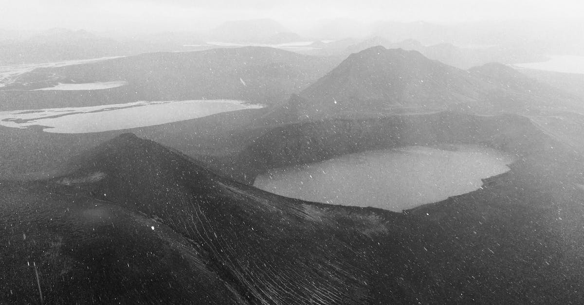 What is the minimum height for snowfall in a Taiga biome? - Drone view of geothermal crater lake surrounded by volcanic mountains during snowfall in Iceland