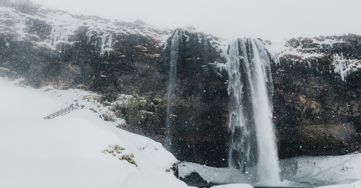 What is the minimum height for snowfall in a Taiga biome? - Majestic view of rocky slope with snow falling in calm river against foggy highland in winter day in cold nature