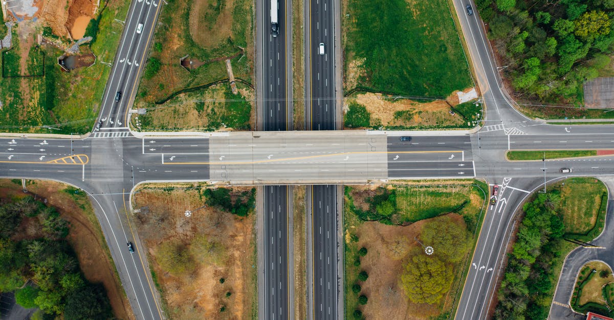 What is the most cost effective way to grow a fairy? - Highway junction with marking lines near green trees in suburb