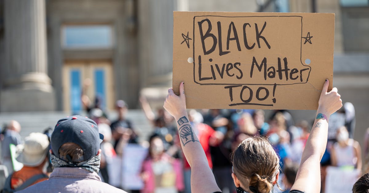 What is the most effective defence strategy in Clash of Clans? - People standing together with cardboard poster during demonstration calling for attention to problem of discrimination against black people