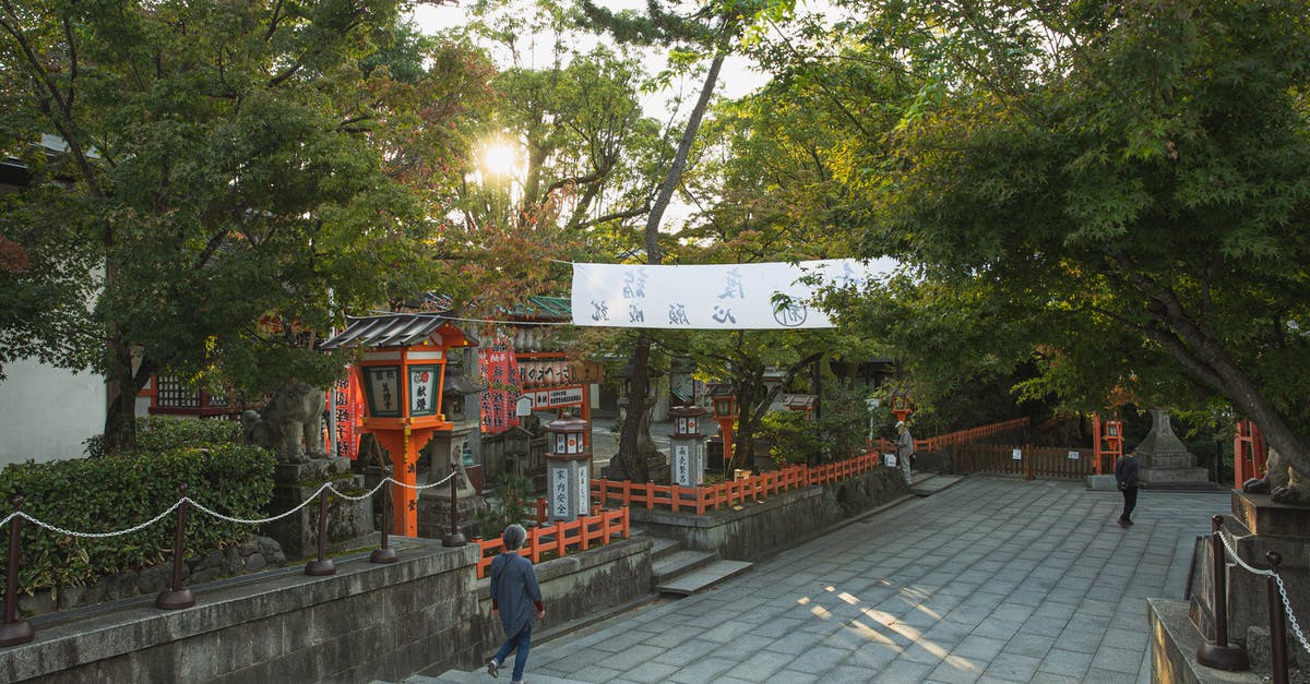 What is the most effective way to grind for drops from the three spirit dragons? - Unrecognizable people walking on paved pathway near green trees while sightseeing ancient Yasaka Shrine located in Kyoto