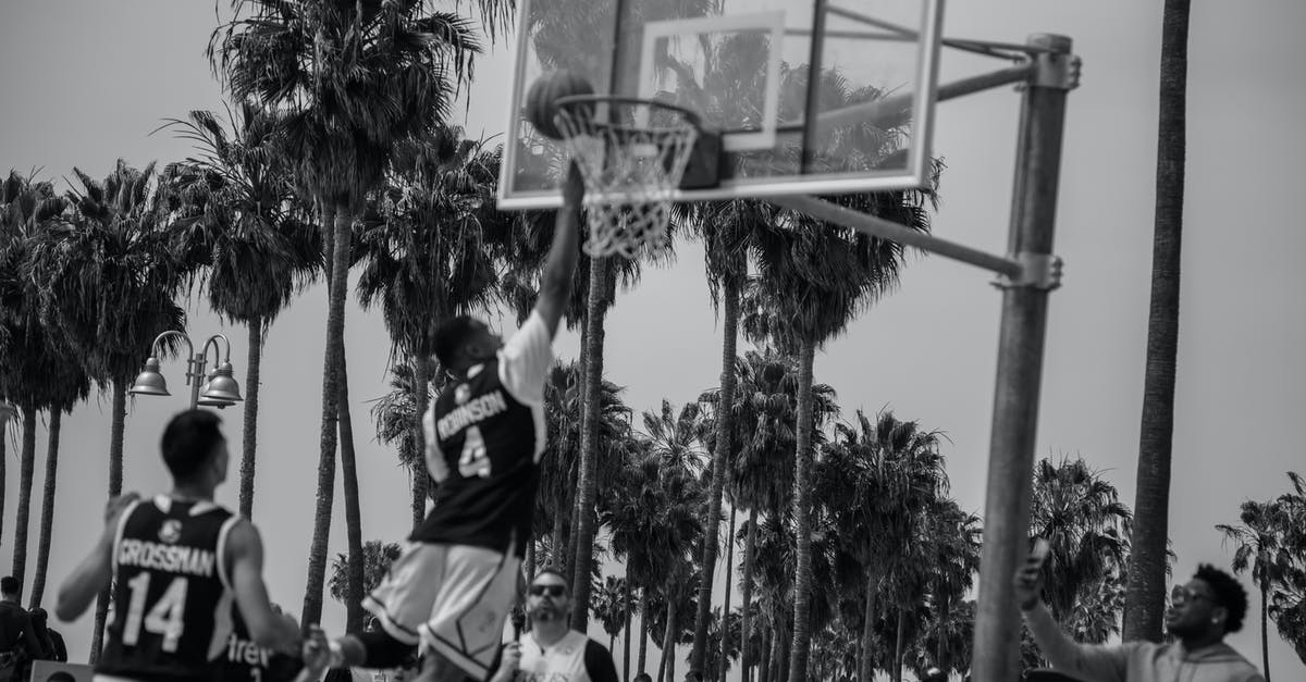 What is the name of this old shooting game? - Grayscale Photo of People Sitting on Basketball Court