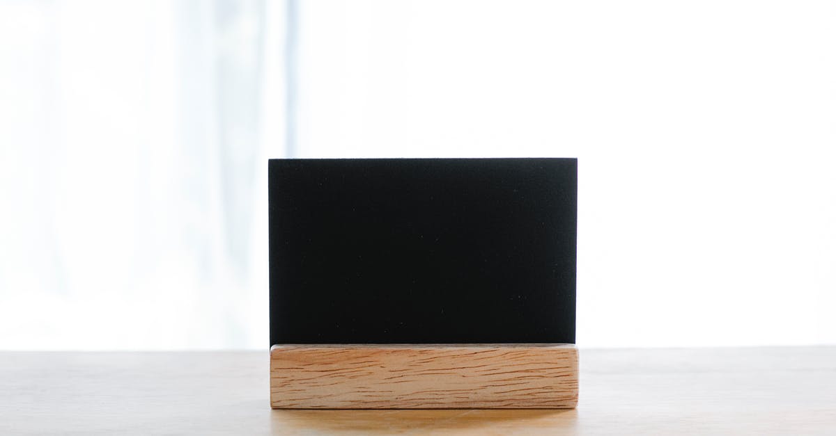 What is the name of this space game? - Empty black name card on wooden holder placed on desk in modern workplace