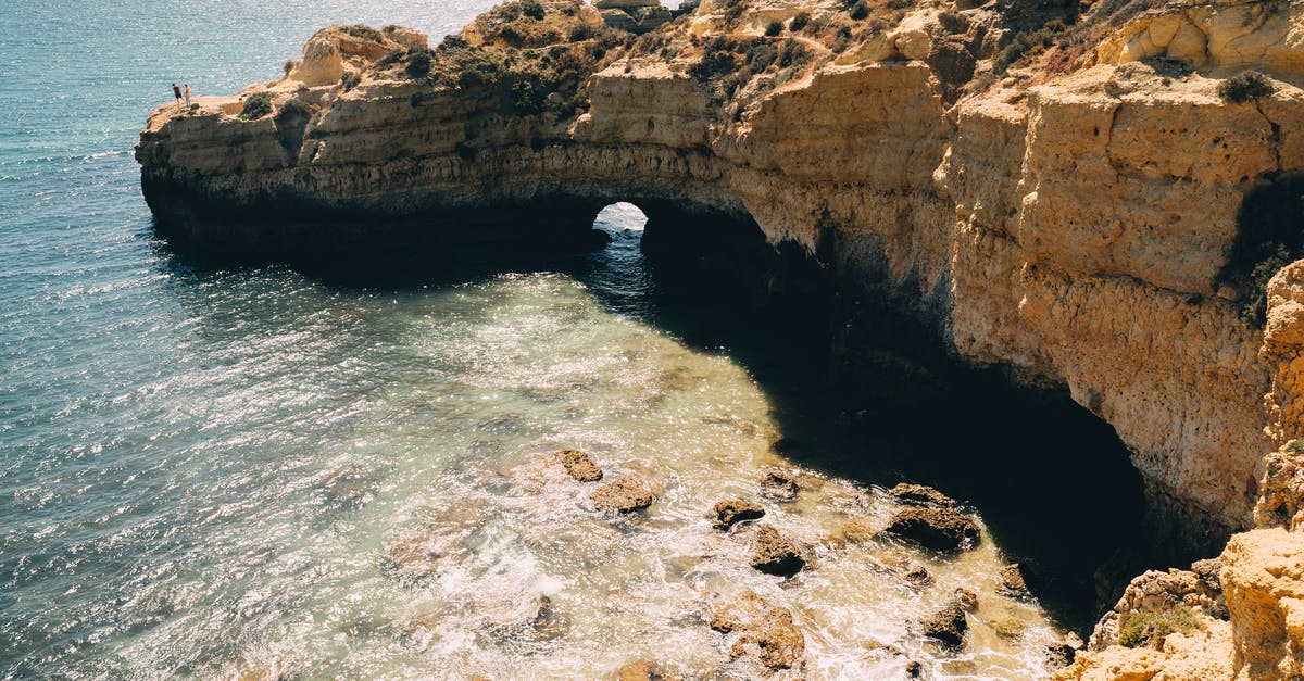 What is the number by the Treasure Cave - Person in Blue Jeans and White Sneakers Sitting on Rock Formation