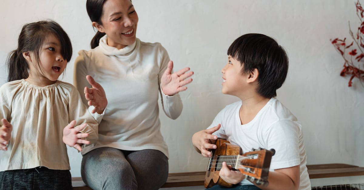 What is the opening song of Borderlands: The Pre-Sequel? - Happy ethnic mother and daughter clapping hands and singing song while positive son playing Hawaiian musical instrument at home