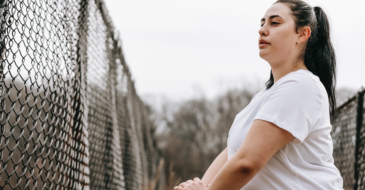 What is the optimal grid size? - Plump woman stretching legs near net fence What is the optimal grid size? - Plump woman stretching legs near net fence