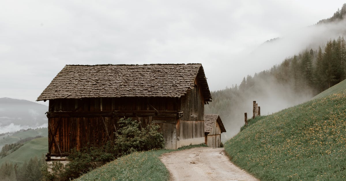 What is the optimal path in Yoshis Valley? - Old rural brown houses with triangle roof on mountain slope covered with grass and yellow flowers next to road and forest on mountain in fog