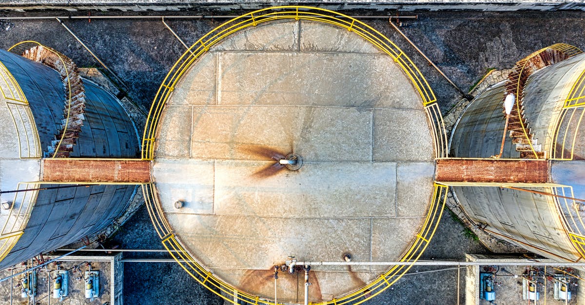 What is the optimum Uranium Refinery to Large Reactor ratio? - Top view of huge industrial tanks connected with rusty passages located at territory of factory