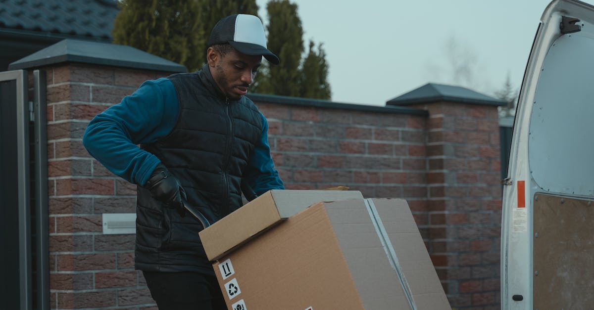 What is the order of ringing the bells for the quest Buried Secrets? [duplicate] - Man in Blue Jacket and Black Cap Holding Brown Cardboard Box