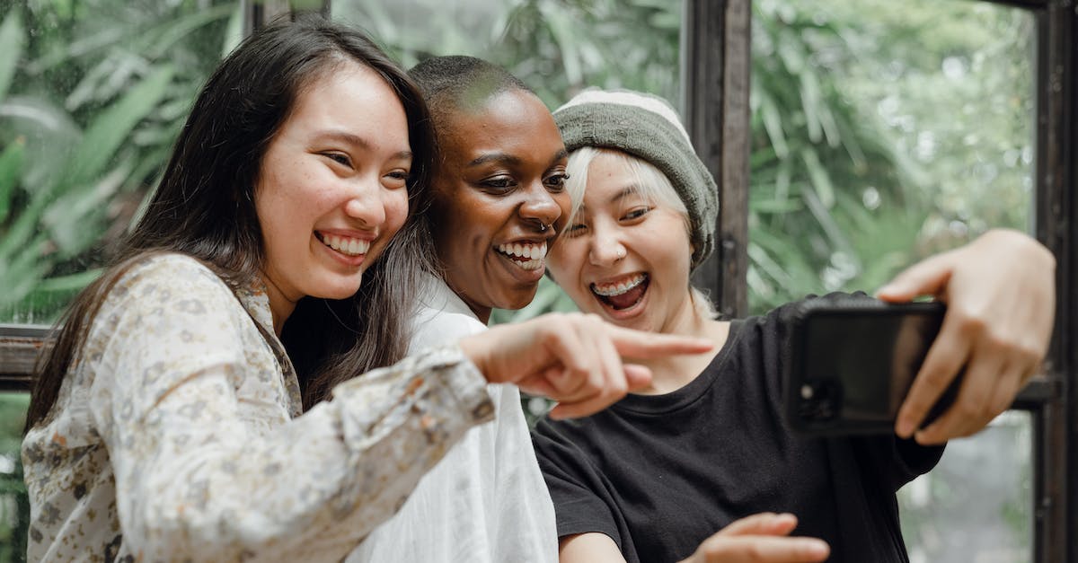 What is the point of having friends? - Cheerful diverse female friends laughing at just taken selfie