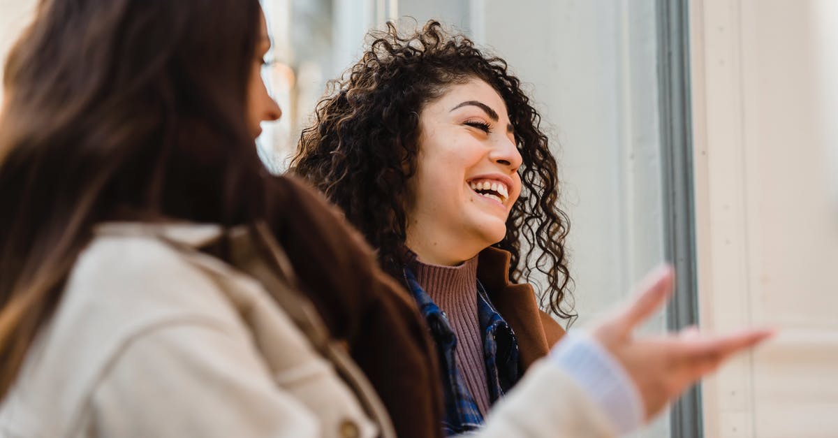 What is the point of investing in shops? - Cheerful young diverse ladies laughing on street