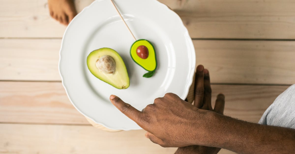 What is the point of Raw weapons? - Top view of crop anonymous African American man pointing on organic healthy avocado helping child to choose between natural fruit and sweet lollipop