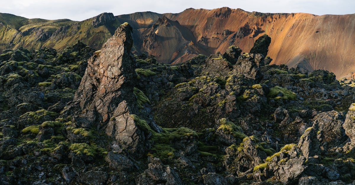 What is the point of Trivia Crack levels? - Spectacular view of sandy ridge in front of pointed rocks with rough partially mossy surface under cloudy sky in afternoon