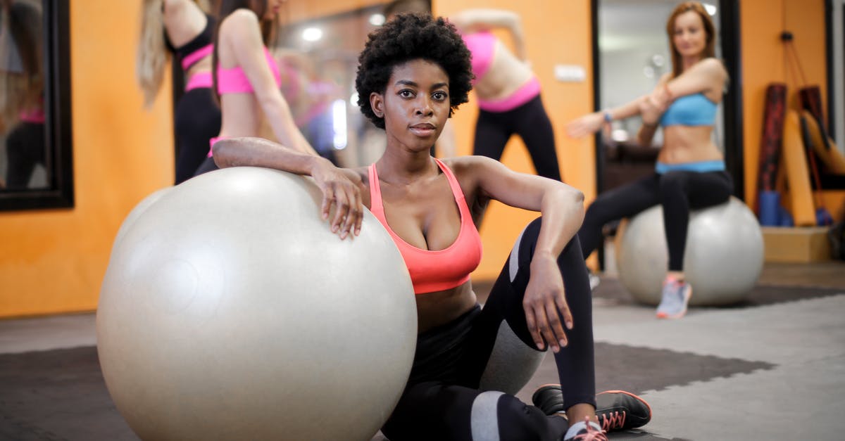 What is the significance of having 0 health and the last health slot shaking, exuding black spots? - Young ethnic woman with fit ball sitting on floor while training in modern gym