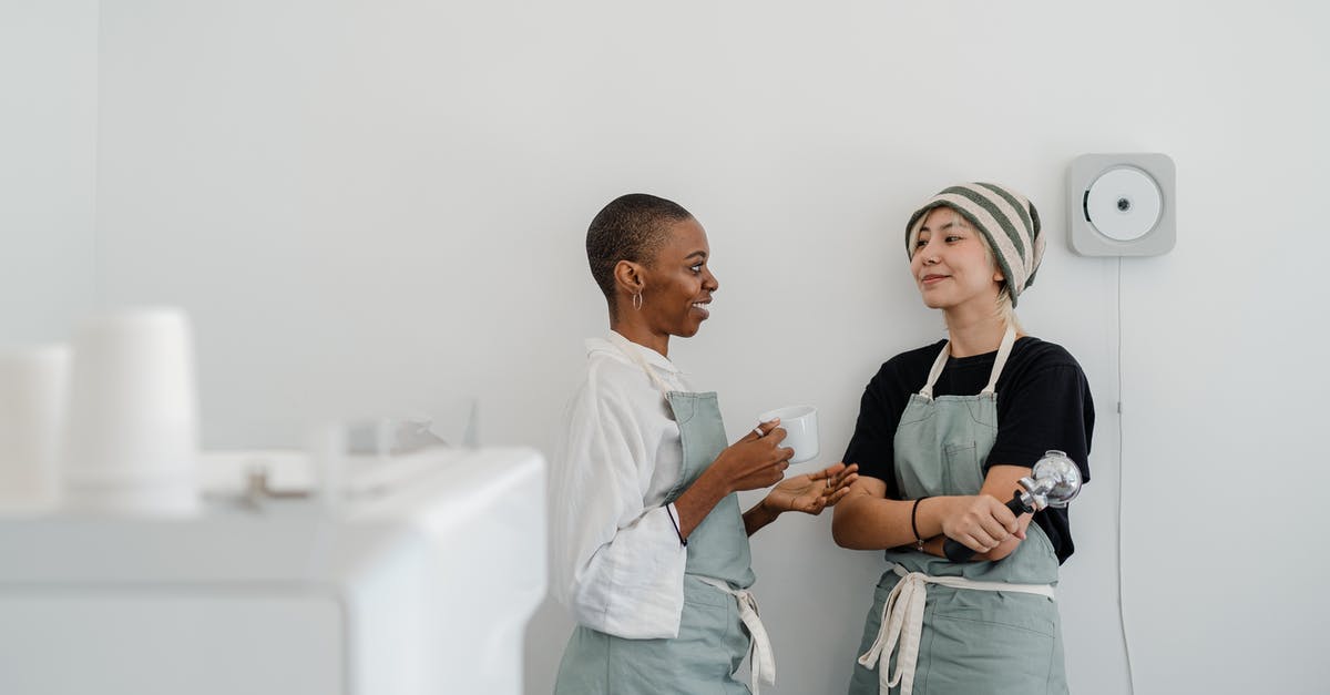 What is the significance of other locked staff members? - Couple of multiracial female baristas wearing apron standing near wall in modern coffee shop with minimal interior while drinking coffee and communicating and looking at each other What is the significance of other locked staff members? - Couple of multiracial female baristas wearing apron standing near wall in modern coffee shop with minimal interior while drinking coffee and communicating and looking at each other