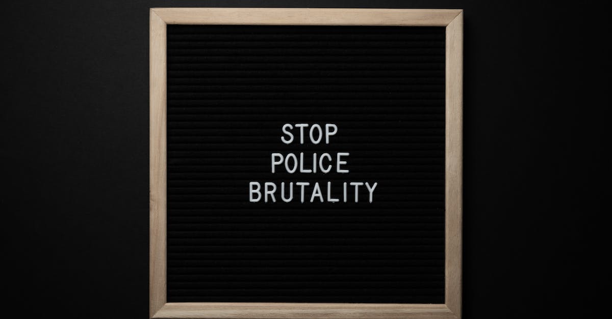 What is the significance of "The letters are worn beyond recognition"? - Overhead view wooden frame with white inscription about social injustice on black background