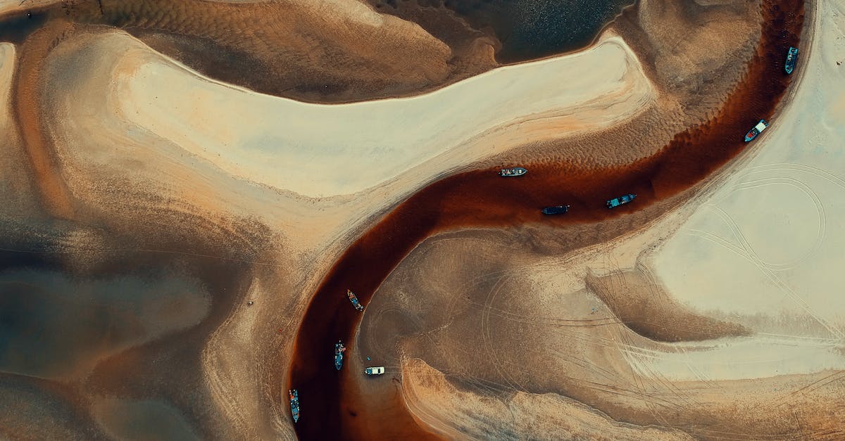 What is the thinest layer of sand that will still produce desert biome? - Aerial-photography of Boats on River Surrounded by Desert