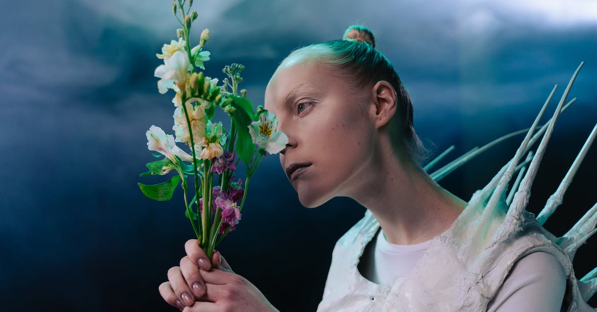 What is the Trigger for Biota Attacks in Alien Legacy? - Woman in White Long Sleeve Shirt Holding White Flower