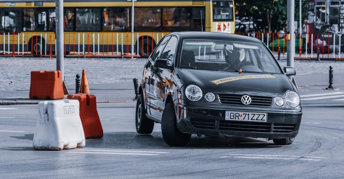 What is the way to determine traits in dialogue? - Black fast automobile driving through barriers on asphalt road against city district with bus route