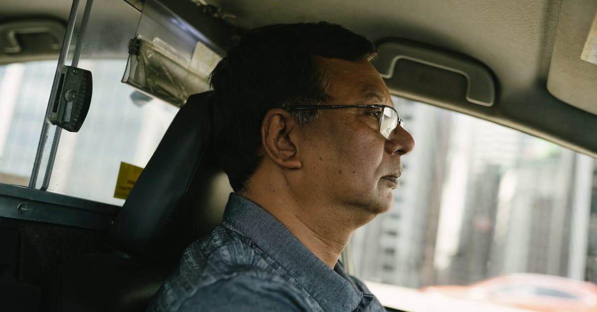 What is this downtown side job during the Corpo prologue? - Side view of ethnic male in eyeglasses and casual clothes looking away while driving car