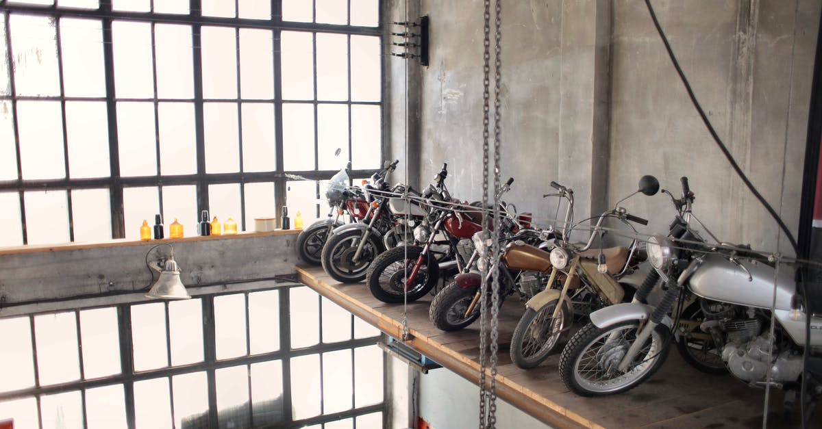 What is this machine in Wall Market? - Retro motorbikes parked in row on special platform in garage What is this machine in Wall Market? - Retro motorbikes parked in row on special platform in garage