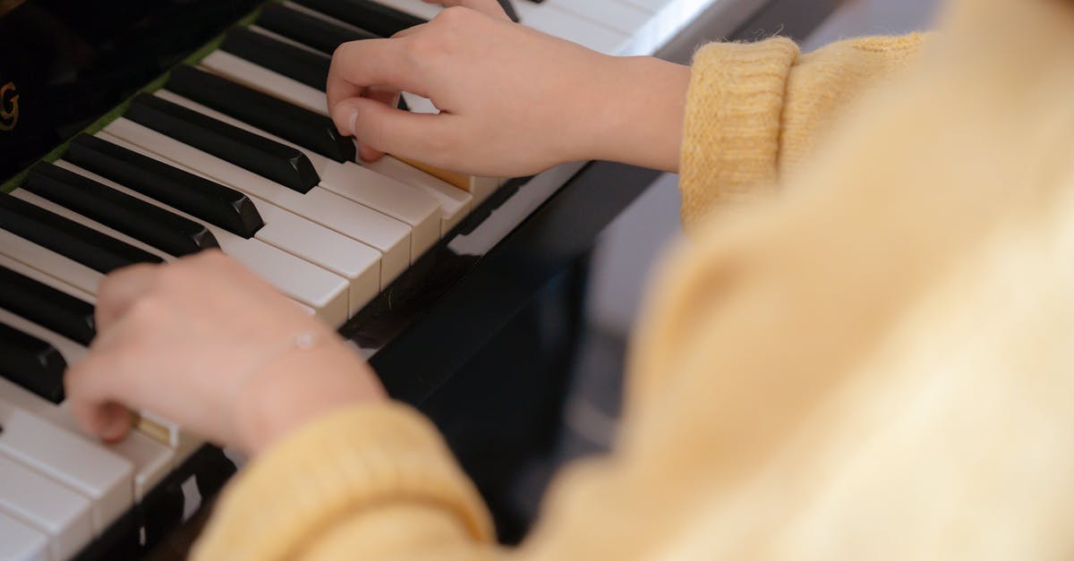 What key do I press to turn on "Extra Lights" on ETS2? - From above of crop unrecognizable female musician in warm pullover sitting on piano stool and touching black and white keys What key do I press to turn on "Extra Lights" on ETS2? - From above of crop unrecognizable female musician in warm pullover sitting on piano stool and touching black and white keys