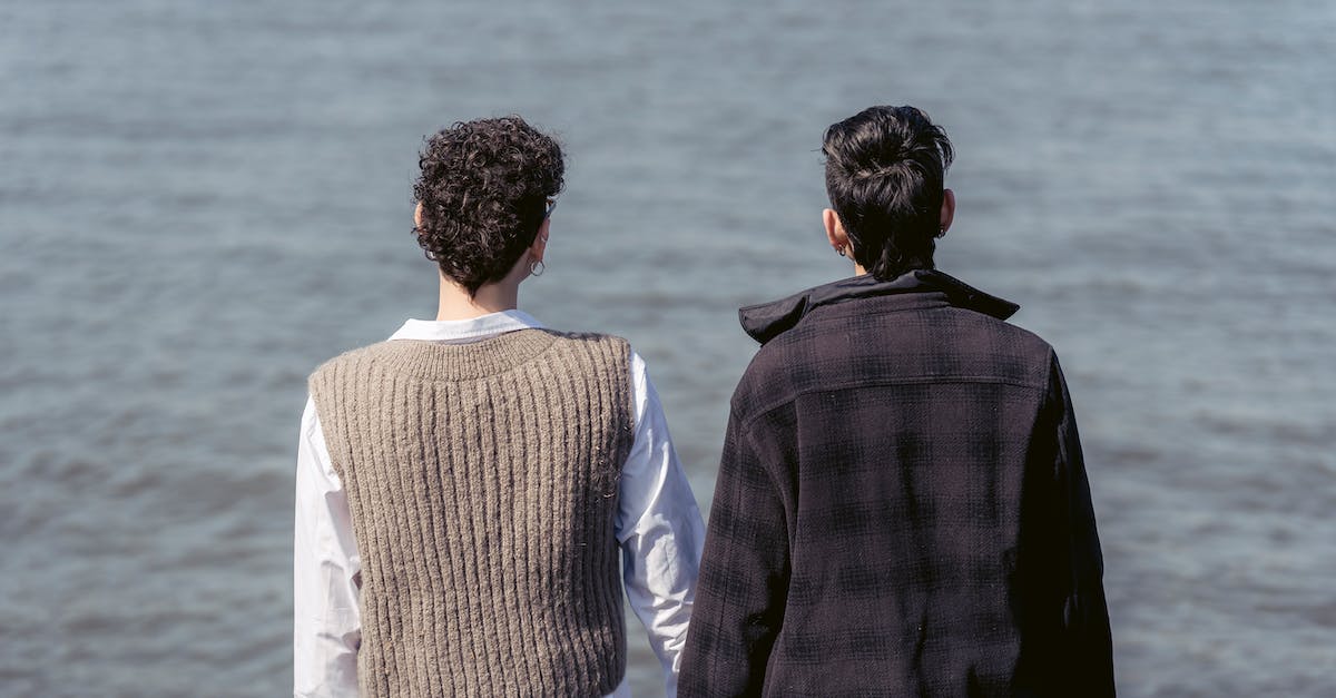 What level of enchantment gives me the best chance for Aqua Affinity or Respiration? - Back view of unrecognizable best friends in warm clothes admiring rippling water of river