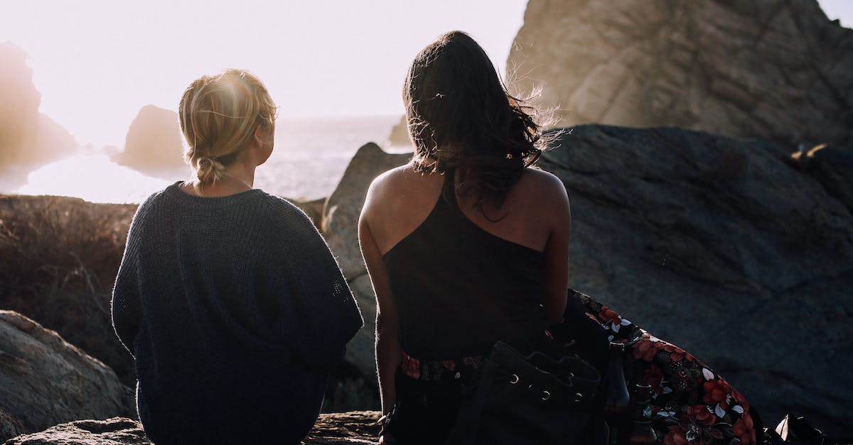 What level of enchantment gives me the best chance for Aqua Affinity or Respiration? - Back view of anonymous best friends talking and resting on heavy stones in bright sunshine near ocean