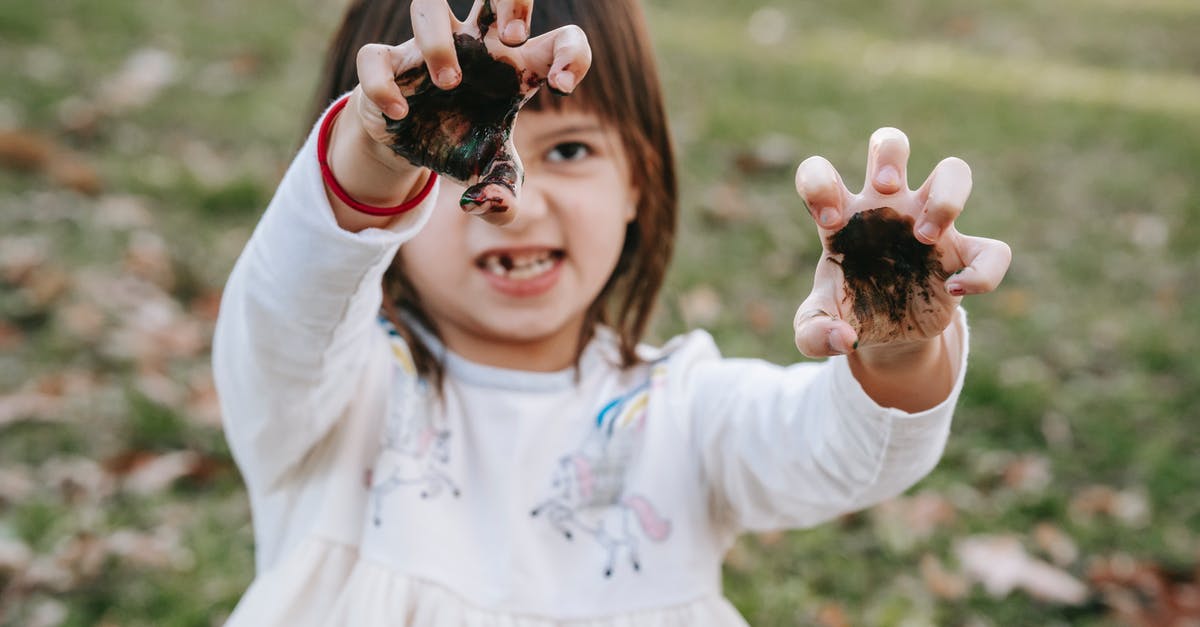 What makes the player character 'different'? - Funny girl with painted hands making scary face while playing in park during Halloween celebration What makes the player character 'different'? - Funny girl with painted hands making scary face while playing in park during Halloween celebration