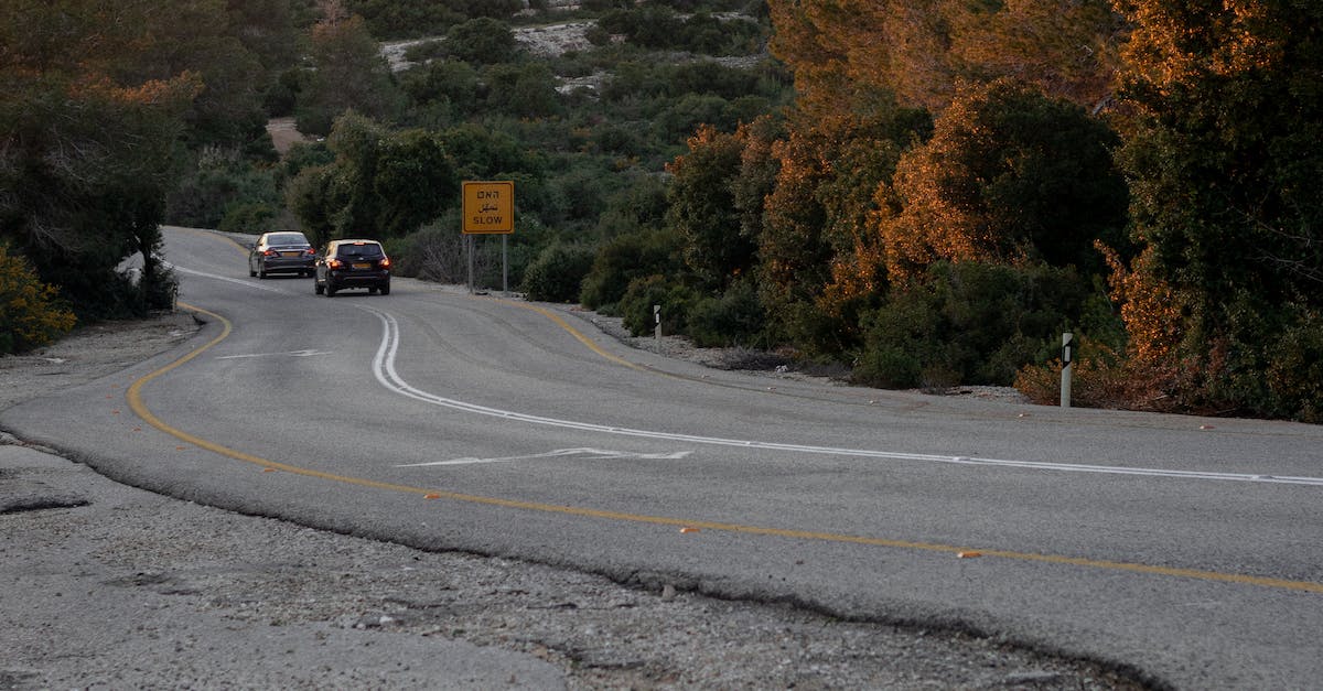 What route across levels 22-25 avoids all spikes? - Narrow curvy asphalt countryside roadway running between lush autumn trees with cars riding in distance